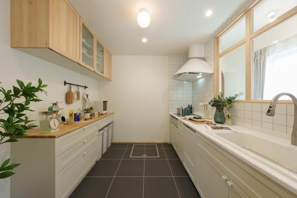 三佐　BERSAのキッチン|ナチュラルな木目調の収納と白を基調とした空間が調和しています。広々とした作業スペースが魅力です。窓からの自然光が明るさを演出し使い勝手の良さが感じられます。シンプルながらも落ち着いたデザインです。