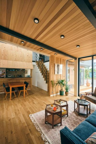 明治北　FREAK'S　HOUSEの居間・リビング|木材をふんだんに使用した温かみのあるリビングです。大きな窓から自然光が差し込み室内が明るく感じられます。天井のデザインや梁が空間にアクセントを加えています。