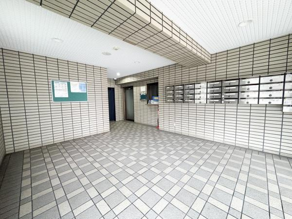 パークサイドおおみちのエントランス|エントランスはゆとりのある空間でタイル張りのデザインが特徴的です。掲示板や郵便受けが整然と配置されています。エレベーターや通路へのアクセスもスムーズです。