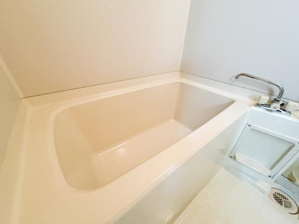 パークサイドおおみちの浴室|シンプルなデザインが特徴のバスルームです。角に配置された蛇口が使いやすさを高めています。浴槽の形状がスペースを有効に活用できる設計です。