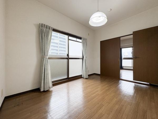 パークサイドおおみちの洋室|大きな窓から自然光がしっかり差し込む洋室です。ナチュラルなフローリングが落ち着いた空間を演出しています。隣室への引き戸もあり使い勝手の良い間取りです。