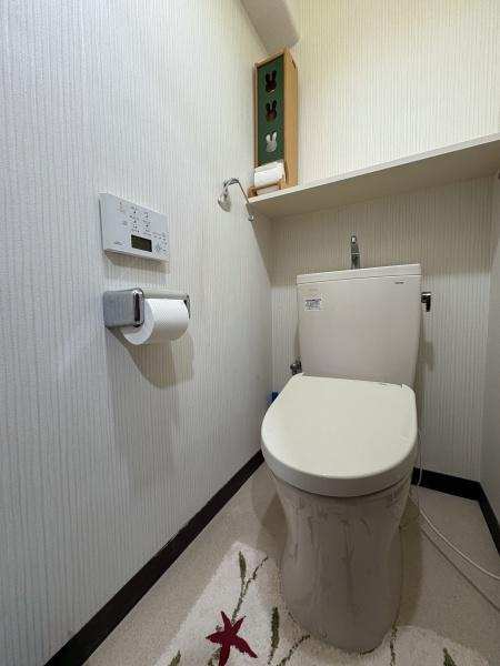 パークサイドおおみちのトイレ|明るい印象のトイレです。壁面にはリモコン式の洗浄機能が設置されています。収納棚にはペーパーや小物を置けるスペースもあります。
