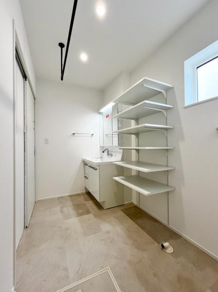 横尾　9号地の独立洗面台|シンプルで使いやすい洗面台と棚が備えられた洗面所です。明るい色調の内装で清潔感があります。収納スペースが豊富で整理整頓がしやすい設計です。