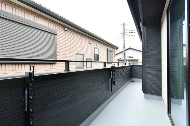 伊奈町小室10期　全1棟のバルコニー|2部屋から出入り可能な使い勝手の良い設計。洗濯物はもちろん布団干しも余裕の広さです。周囲の視線を遮りつつ開放感を得られる高さのパネルを採用し、プライバシーを守りながら日々の家事を心地よくこなせます。