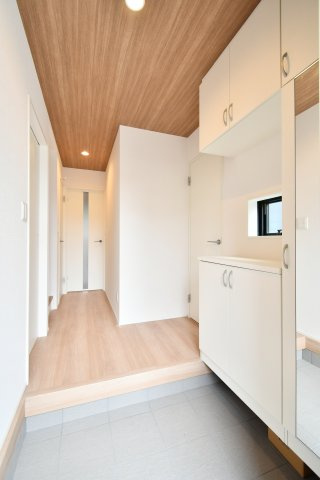 伊奈町小室10期　全1棟の玄関|ミラー付き下駄箱でお出かけ前の身だしなみチェックも。圧迫感のないホワイト基調の空間に、木目のアクセントが光ります。ホールから居室への繋がりもスムーズで、暮らしの機能美を追求した設計です。