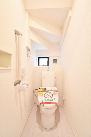 伊奈町小室10期　全1棟のトイレ|白を基調としたクリーンな空間。小窓からの自然光と換気機能で、常に爽やかな状態をキープできます。手すり付きのバリアフリー設計や便利な収納棚など、家族全員が毎日心地よく使える優しい仕様です。