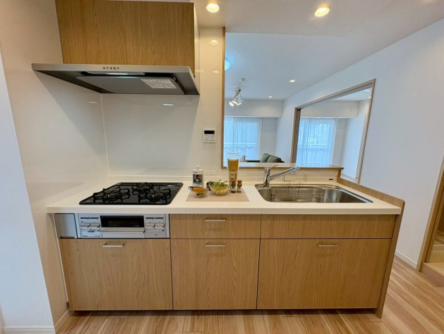「室内キレイ」アルファステイツ桟橋通り　中古マンションのキッチン|木の温もりを感じるシステムキッチン。豊富な収納と広い作業スペースで家事動線もスムーズです。