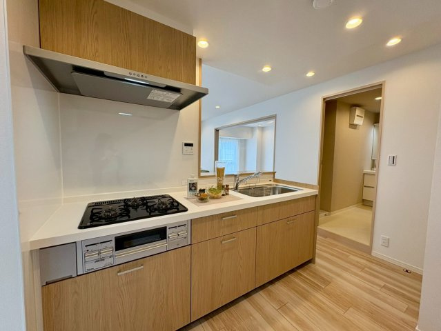 「室内キレイ」アルファステイツ桟橋通り　中古マンションのキッチン|温かみのある木目調のシステムキッチン。収納も豊富で、毎日のお料理がより楽しく快適にはかどります。
