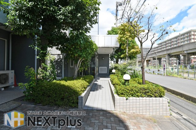 クレセント東鷲宮のエントランス|植栽が整えられたアプローチは、道路からエントランスへ続く動線がわかりやすい配置です。スロープ付きのため、出入りのしやすさや共用部の雰囲気も現地で確認しやすい写真です。