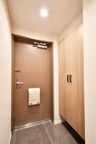 クレセント東鷲宮の玄関|住まいの顔となる玄関は、木目調の大型シューズボックス付き。散らかりがちな靴をスッキリ収納し、常に清潔感ある空間を保てます。落ち着いた色調の玄関ドアが、帰宅した家族を優しく迎え入れるデザインです。