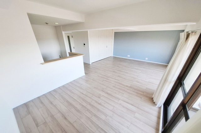 朝日プラザシティ・サザンパーク四番街の居間・リビング|アッシュ系のライトなフローリングと爽やかなブルー系のアクセントクロスで仕上げたリビングダイニング