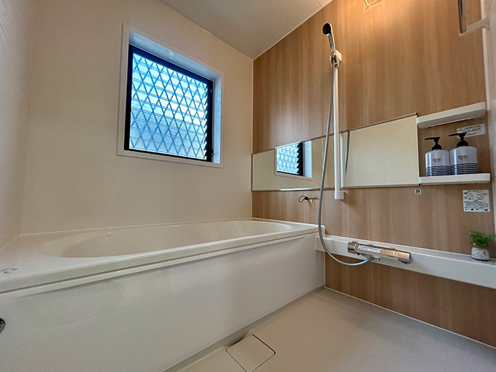 松山市西長戸　再生住宅の浴室|1坪以上の広々としたバスルームは、窓からの光が心地よいリラックス空間。追い焚き機能付きの新品浴槽で、いつでも温かいお湯に包まれる。一日の疲れを癒やす、家族みんなのお気に入りの場所。