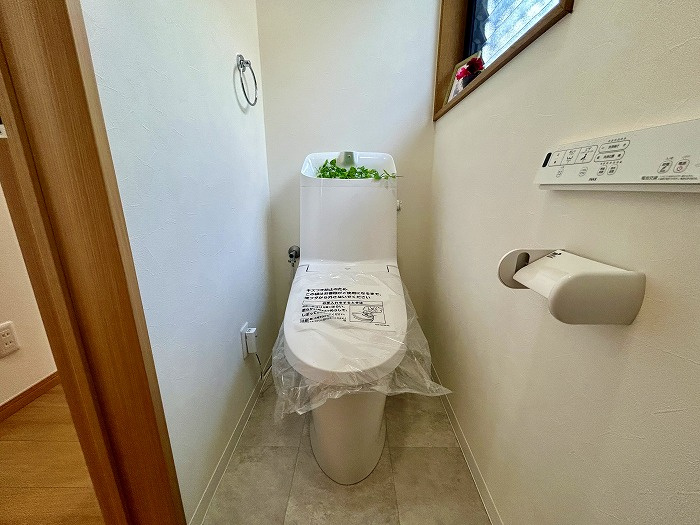 松山市西長戸　再生住宅のトイレ|1階と2階の2ヶ所にトイレを設置し、どちらも新品に交換済み。温水洗浄便座などの快適機能はもちろん、お掃除のしやすさも魅力。忙しい朝も順番を気にせず、清々しい気持ちで一日をスタートできる。