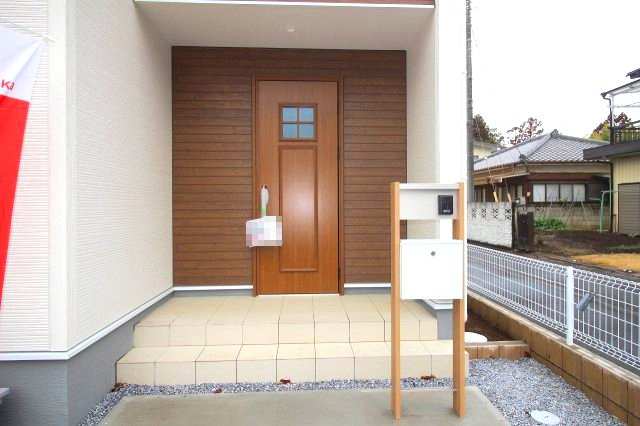 野木町若林　第２の玄関|木目調の玄関ドアとアクセント外壁が調和した、おしゃれで落ち着いた印象の玄関です！ポストやインターホンも設置されており、毎日の出入りも安心です。