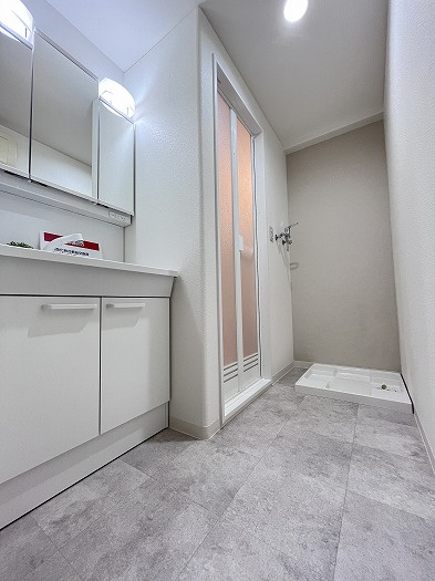 スプレンド保免の洗面所|リフォームされた清潔な空間で、一日の始まりを爽やかに。広めの脱衣スペースは着替えもスムーズで、洗濯機置き場も使いやすく配置。毎朝の身支度が整う場所だからこそ、明るく使い勝手の良い設計が嬉しい。