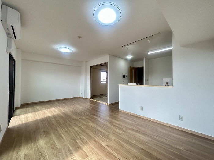 スプレンド保免の居間・リビング|15帖以上の広々としたリビングは、大きなソファを置いてもゆとりたっぷり。フローリングも張り替え済みで、家族が自然と集まり、思い思いの時間を過ごせる。明るい光が差し込む空間で、団らんのひとときを楽しむ。