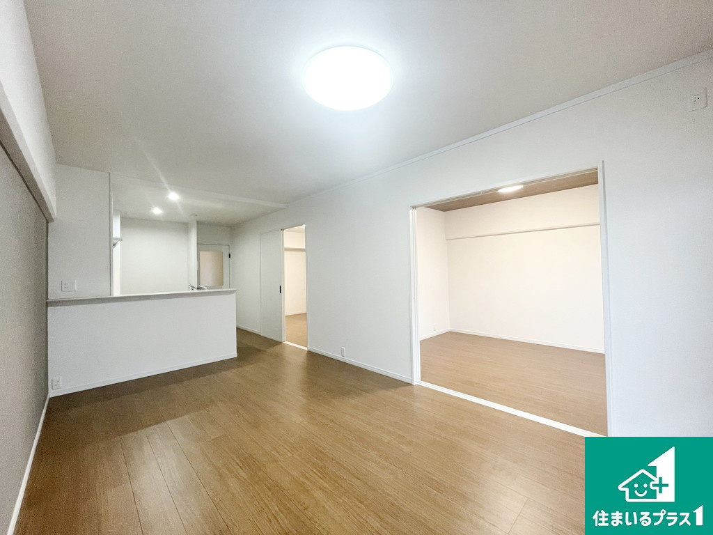 エバーグリーン金岡四号棟の居間・リビング|リビングはブラウンのフローリングに張替え！リビング繋がりで２部屋洋室もあり、家族同士のコミュニケーションが自然に増えます！【現地写真】