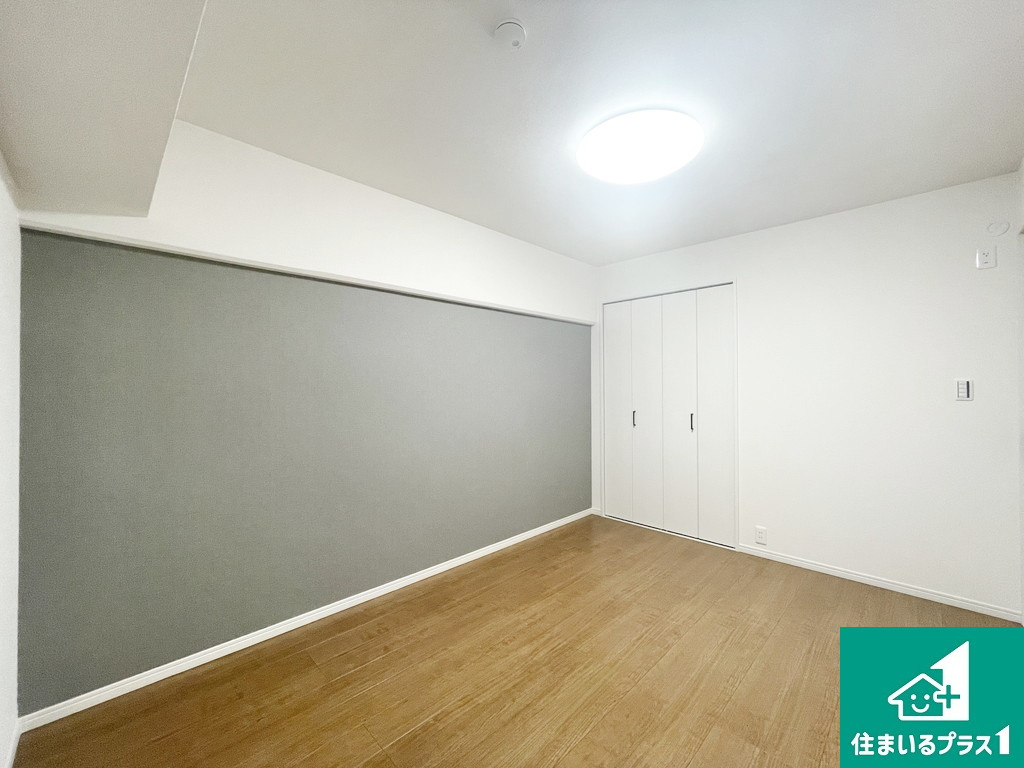 エバーグリーン金岡四号棟の子供部屋|キッチンに面した洋室はグレーのアクセントクロスでシックな雰囲気を演出！バルコニーにも面し日当たり良好！【現地写真】