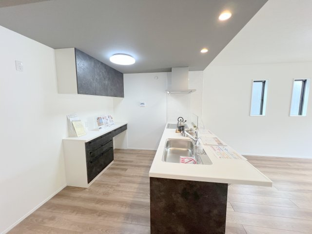 羽村市羽中2丁目　新築戸建全3棟のキッチン|キッチンには備え付けのカップボードが標準でついています。キッチンと色合いも統一されて収納豊富な設備。