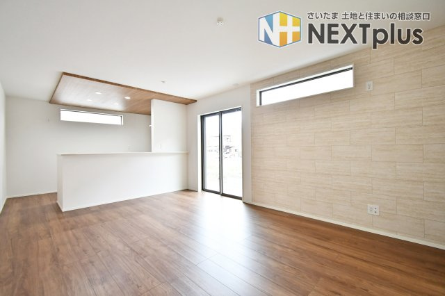 蓮田市西新宿11期　全1棟の居間・リビング|全居室南向きの明るい住まい。リビングにはお洒落なアクセントウォールを配し、洗練された空間を演出。高窓からの安定した採光が、家族の団らんを優しく包み込む開放的な設計です。