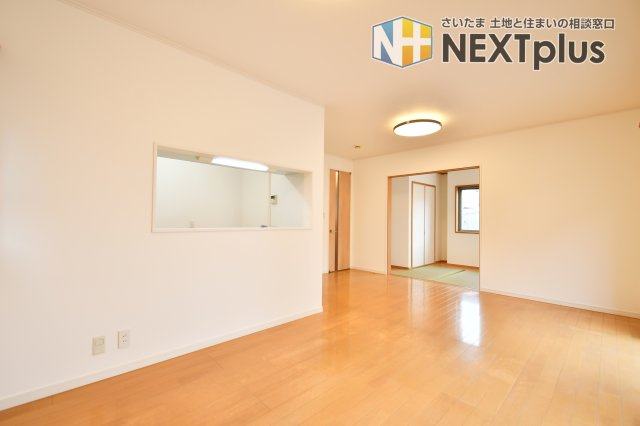 伊奈町西小針1丁目の居間・リビング|リビング横の和室は、お子様の遊び場や客間として多目的に活躍。扉を開放すれば、さらなる奥行きを感じる大空間へと変わります。家事をしながら和室まで目が届く、子育て世帯に嬉しい安心のレイアウト。