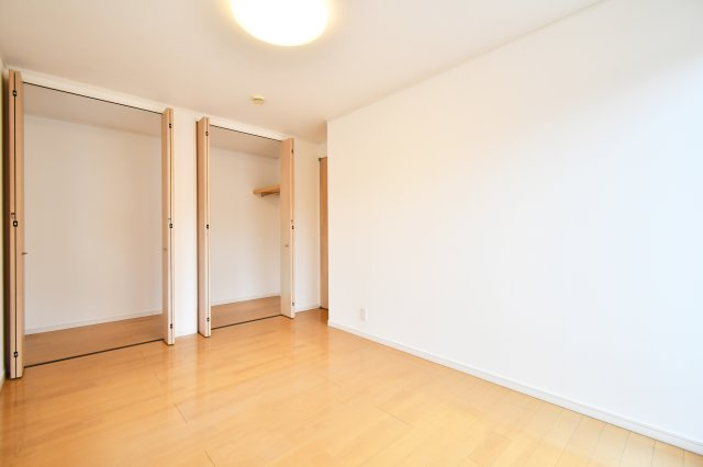 伊奈町西小針1丁目の洋室|7帖の広さを有効活用できるよう、大型の収納スペース付き。夫婦の衣類や季節物もスッキリ収まり、居住エリアは常に美しく保てます。白を基調とした壁紙が光を反射し、部屋全体をより広く感じさせます。