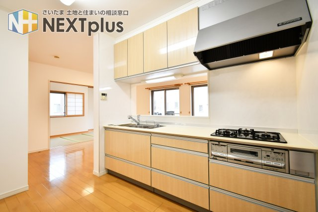 伊奈町西小針1丁目のキッチン|リビングや和室まで視線が届く対面式。3口コンロとワイドな作業スペースで、効率よく調理が可能です。家事をしながらお子様の様子を見守れる安心感。家族の会話が自然と弾む、住まいの中心にふさわしい空間です。