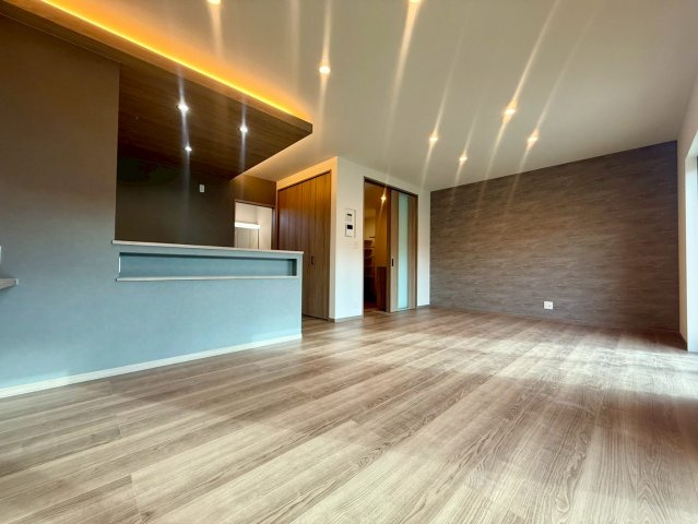 いの町枝川　新築戸建の居間・リビング|木目が美しい広々LDK。間接照明付きで上質なくつろぎ時間を。