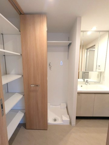 RETERRACE三ノ輪ウエストの洗面所|トイレと独立した洗面脱衣室、三面鏡付洗面台、大型収納付、洗濯機置場は排水口のお手入れしやすい様に手前中央に配置し、足高の防水パンです