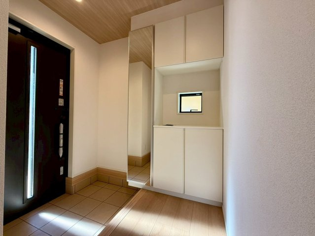 香美市土佐山田町宝町2期5棟 5号棟の玄関|明るい玄関ホールと大容量の収納が魅力。全身鏡付きでお出かけ前のチェックもスムーズにできます