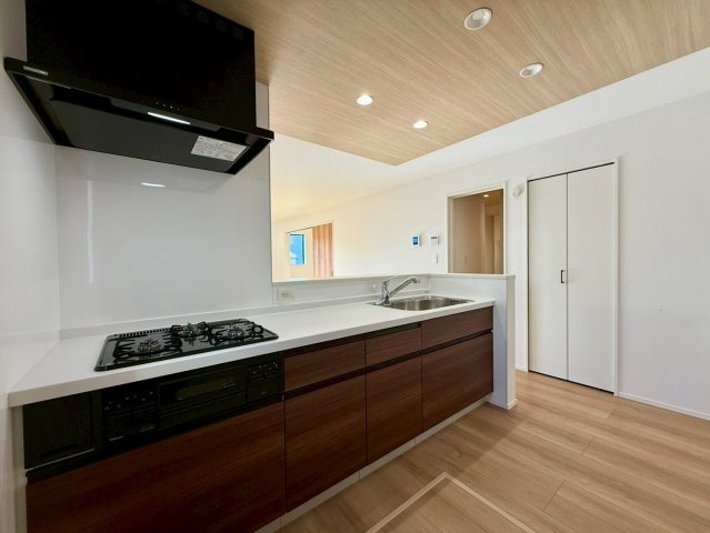 香美市土佐山田町宝町2期5棟 5号棟のキッチン|木目天井が映える対面キッチン。料理しながら家族と会話が弾む、開放的で使いやすい空間です