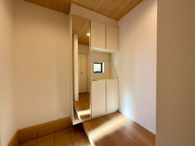 香美市土佐山田町宝町2期5棟 5号棟の玄関|玄関に明るさをもたらす窓と収納。全身鏡付きで、朝の身支度からお出かけ準備までスムーズに整います