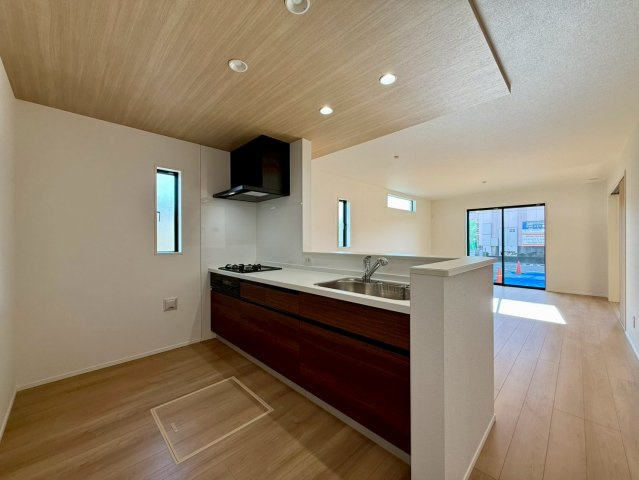 香美市土佐山田町宝町2期5棟 5号棟のキッチン|木目天井が映える対面キッチン。リビング全体を見渡せる家事ラク設計で家族時間がもっと快適に