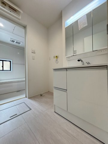 嵐山町志賀　4期　新築一戸建て　グラファーレ　01の脱衣所|広さのある脱衣場は家族の支度がしやすく、洗濯動線もスムーズ◎収納力のある洗面化粧台が備わり、タオルや日用品をまとめてしまえて毎日の家事が快適に進みます。明るい雰囲気で気持ちよく使える点も魅力です!
