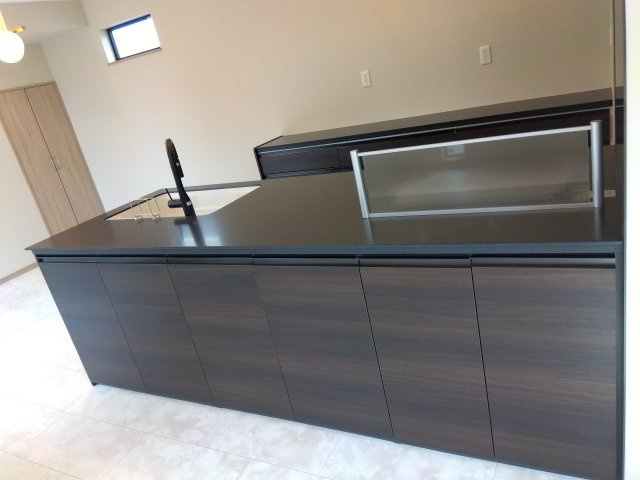 八戸市長苗代内舟渡　B棟の居間・リビング|ライン照明が映える、ブラックを基調としたスタイリッシュなキッチン