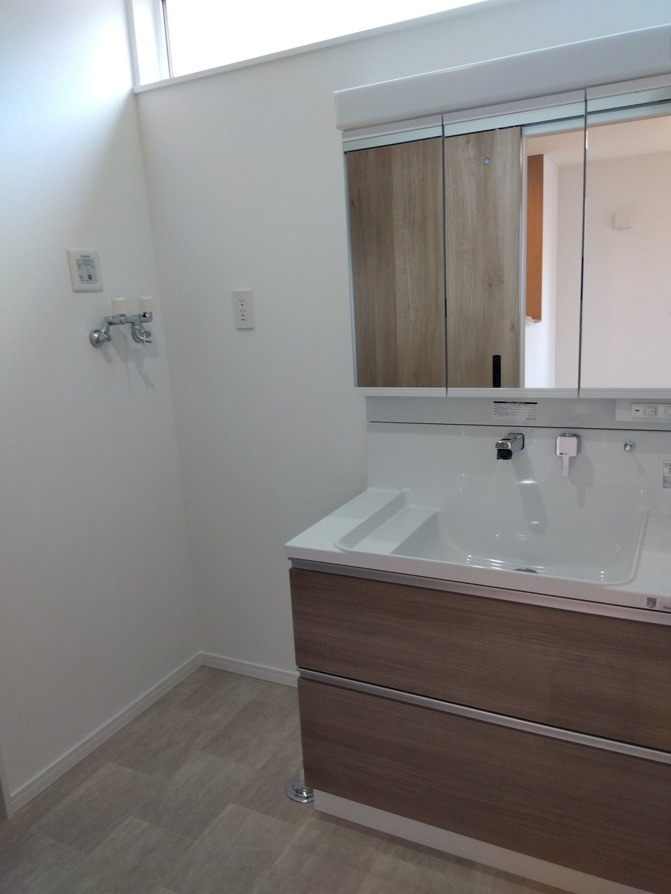 三沢市緑町　A棟の洗面所|三面鏡ですっきりとした印象の洗面スペース。見た目と使いやすさを両立した洗練された空間です