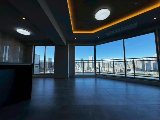 キャナルワーフタワーズWESTの居間・リビング|織り上げ天井の間接照明がアクセントに。
大きな窓からの眺望がポイントの高級感のある空間を演出していま