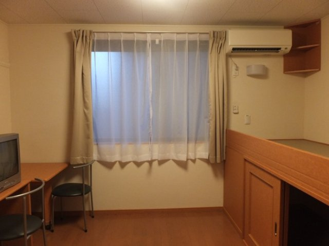 レオパレスサンロードの居間・リビング|ベッド横、下に収納スペースあり