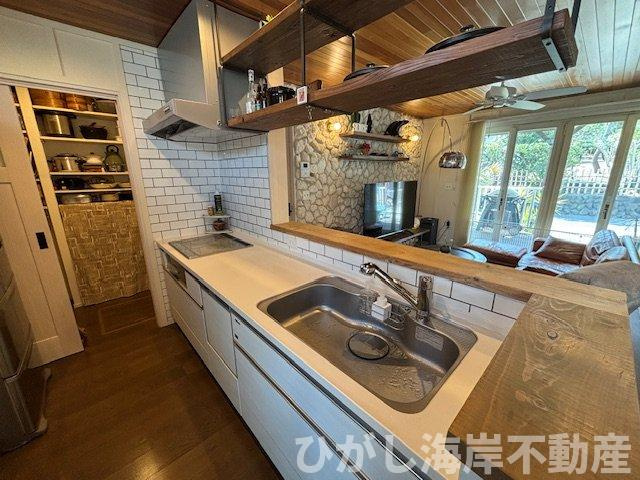 藤沢市鵠沼海岸1丁目　中古戸建のキッチン|リビングを見渡せる対面キッチン×大容量パントリー。
白いタイルと無垢の棚が映える、湘南らしいデザインです。