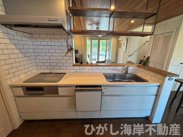 藤沢市鵠沼海岸1丁目　中古戸建のキッチン|タイル張りの対面キッチンがLDKの主役に。木目の勾配天井と調和した、カリフォルニアテイストの心地よい空間です。