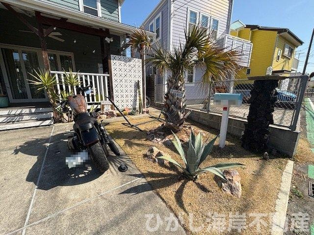 藤沢市鵠沼海岸1丁目　中古戸建の駐車場|ヤシの木が迎える、湘南らしいアプローチ。
カースペースと庭先が一体となり、住まいの世界観を演出します。
