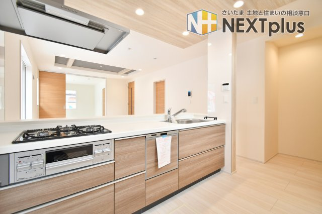 上尾市泉台2丁目2期　全1棟のキッチン|リビング全体を見渡せる設計で、会話を楽しみながらお料理が可能。食洗機や3口コンロなど充実の設備が時短を叶えます。折上天井による開放感あふれるLDKをぜひ現地で体感ください。