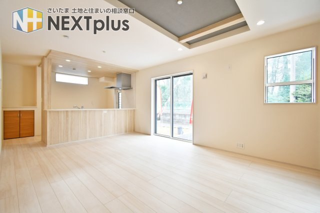 上尾市泉台2丁目2期　全1棟の居間・リビング|折上天井が空間に奥行きと開放感をプラスする、デザイン性の高い16帖のLDK。キッチンからはリビング全体を見渡せ、家族の会話も弾みます。隣接する和室を開放すれば、さらに広々とした大空間が広がります。