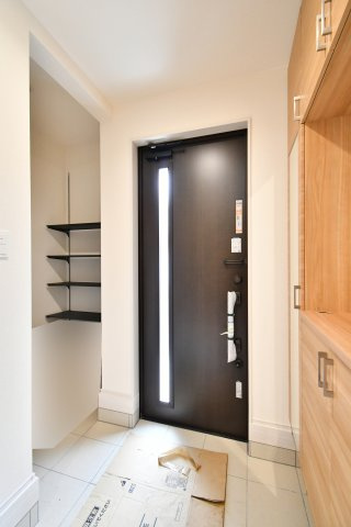 上尾市泉台2丁目2期　全1棟の玄関|ベビーカーやアウトドア用品もそのまま収納できる便利な土間スペースを確保。可動棚付きで、散らかりがちな玄関を常にスッキリ保てます。電池錠採用のドアで、日々の出入りもスマートに。