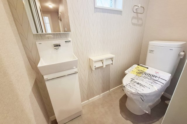 堺市南区美木多上のトイレ|1階トイレ：便器・温水洗浄便座を新調済み。トイレ内に鏡付きの手洗い器があります。