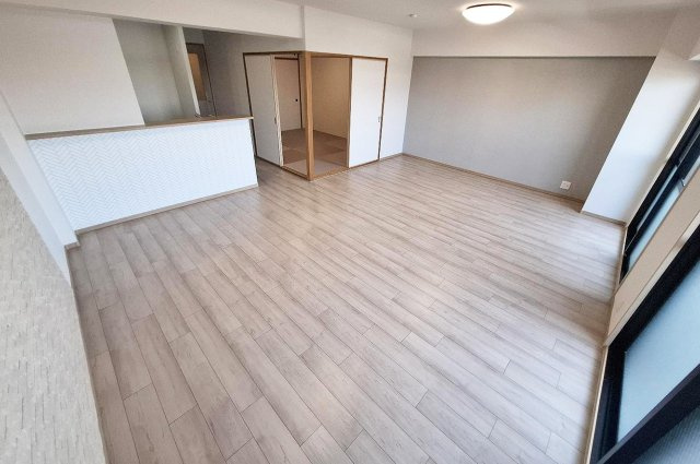 ベルク浜寺公園の居間・リビング|壁一部に施したグレージュのアクセントクロスが、リビングをナチュラルで柔らかい空間にしてくれます。