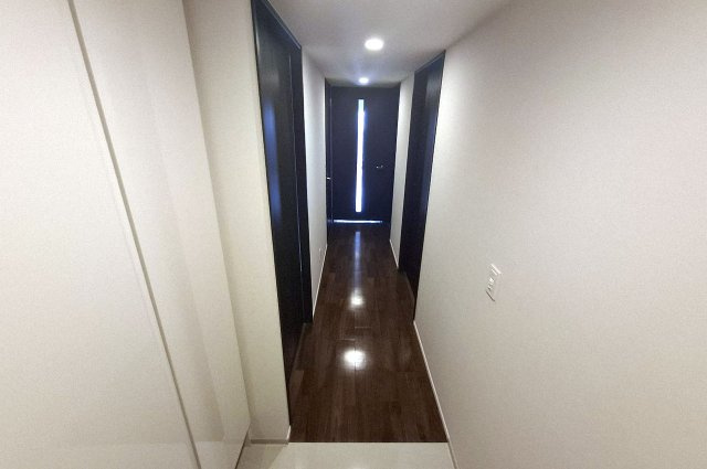 サンメゾン堺浅香駅前の内装|白とダークブラウンのコントラストが美しい廊下部分。高級感のある空間です。