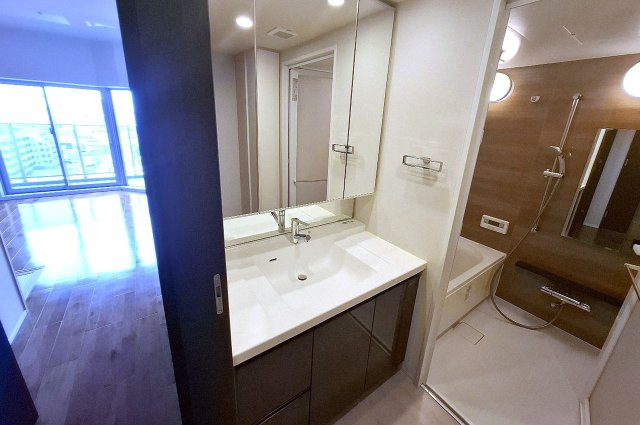 サンメゾン堺浅香駅前の独立洗面台|ワイドな三面鏡付きの洗面化粧台を備えた洗面室。朝の身支度も快適です。