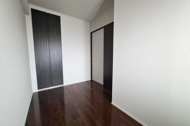 サンメゾン堺浅香駅前の洋室|約5帖の洋室（2）。シンプルな内装とダークトーンの建具が落ち着きを演出します。