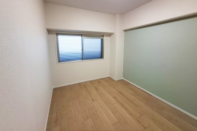 メゾンドール堺の寝室|洋室1：壁一部には爽やかなミントグリーンのアクセントクロスを貼りました。